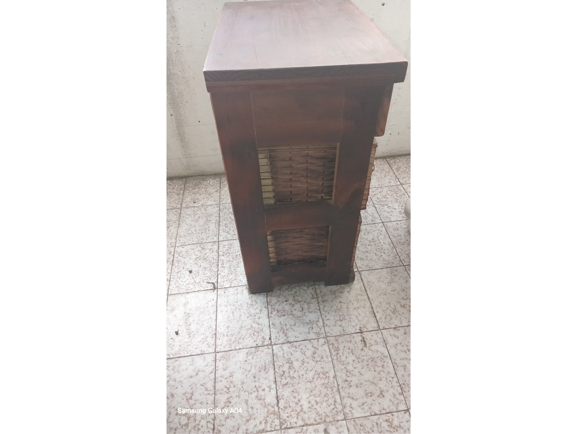 Mesa de luz de madera con cajones de mimbre.